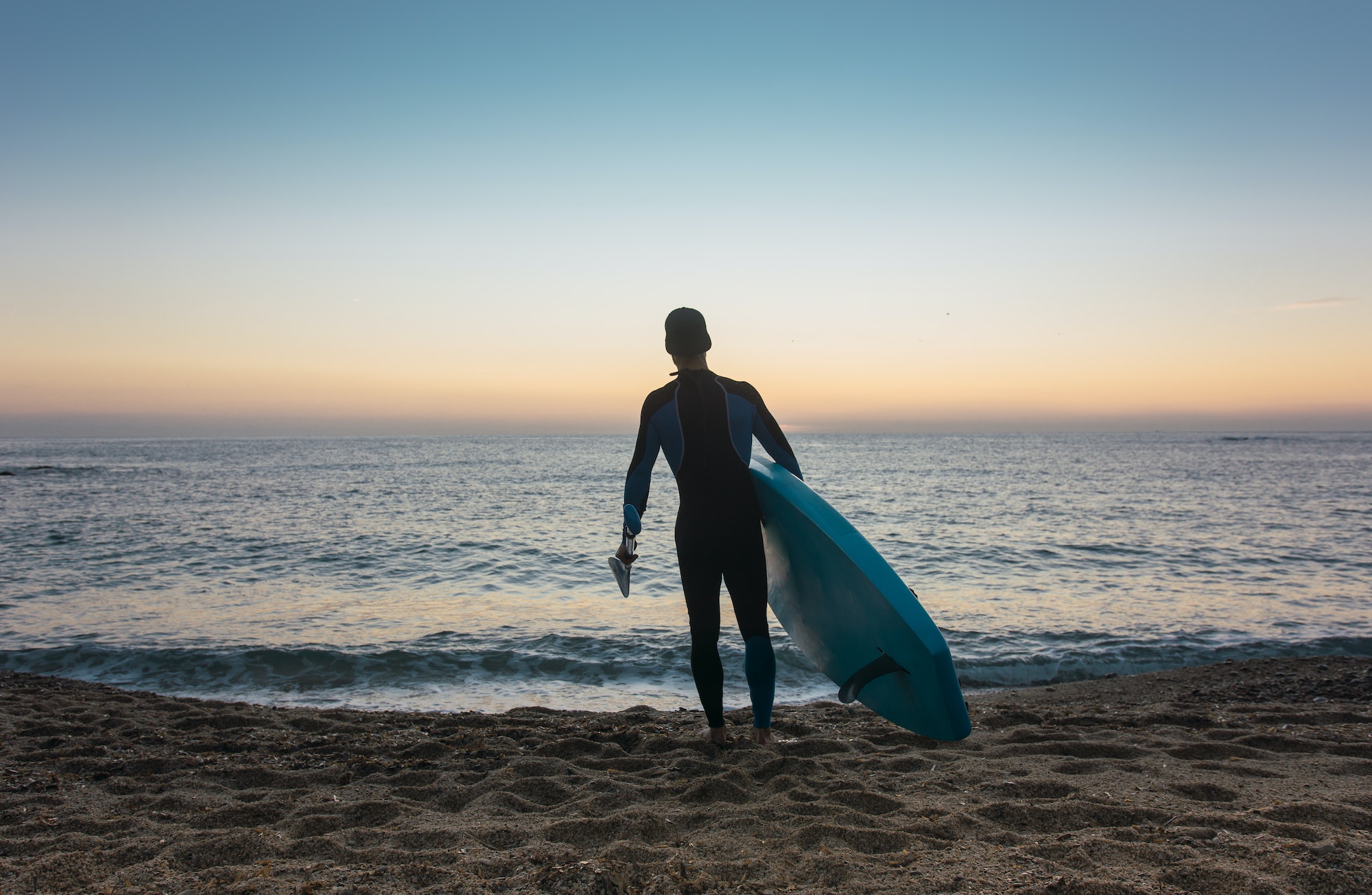 Man practicing paddle surfing with neoprene in a sunrise